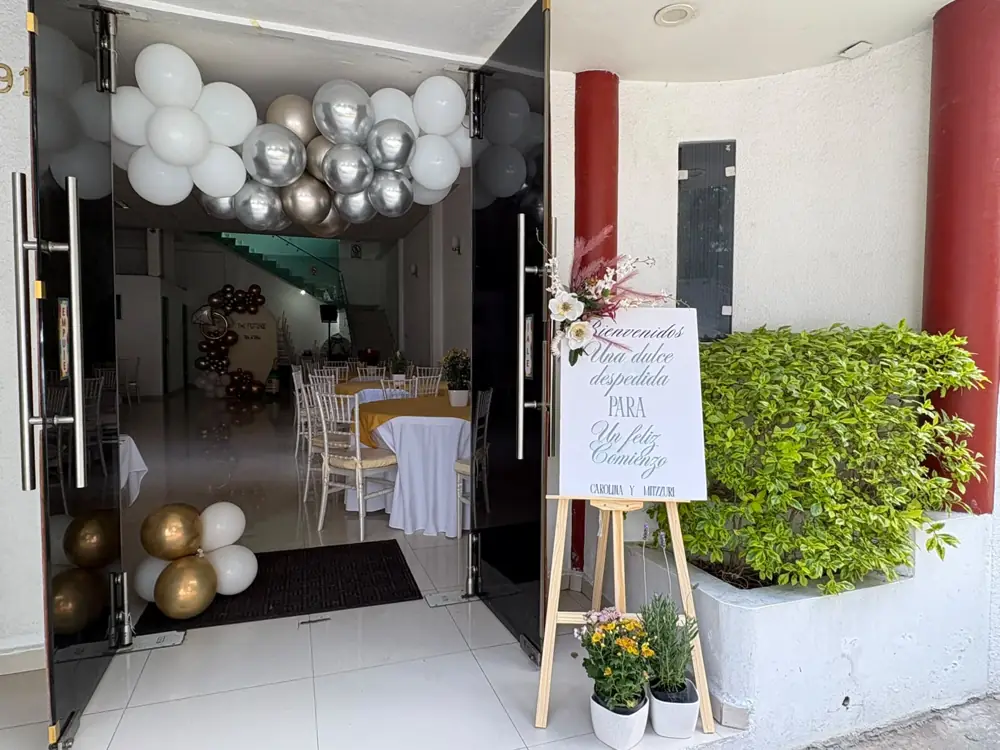 Entrada decorada con globos blancos, plateados y dorados