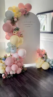 Mampara con globos pastel y arreglo floral